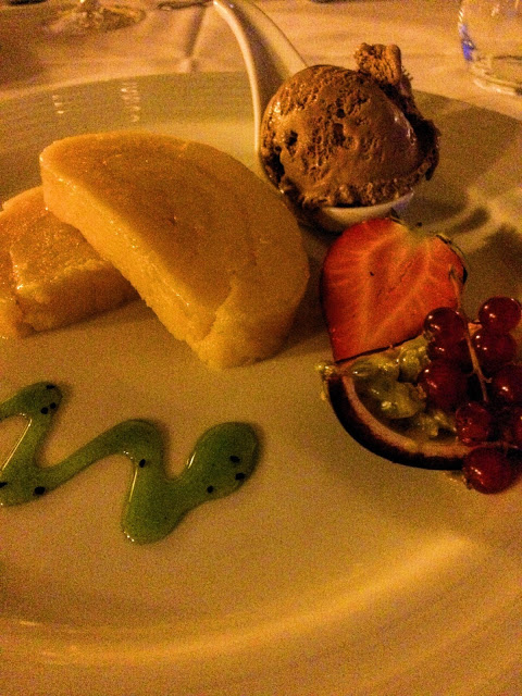 A delicious looking dessert with icecream, souffle, kiwi jelly sauce and some fruits