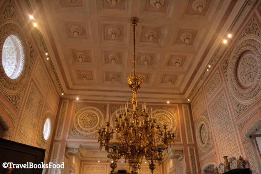 This is a photo of the chandelier inside a pink hall inside the Pena Palace