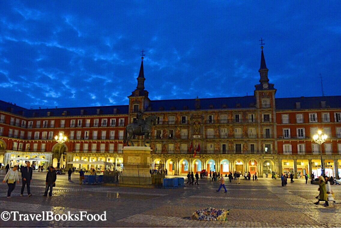 Plaza Mayor is a huge plaza in Madrid, Spain. It is a red building covering four sides of a plaza and this is a photo of it during blue hour