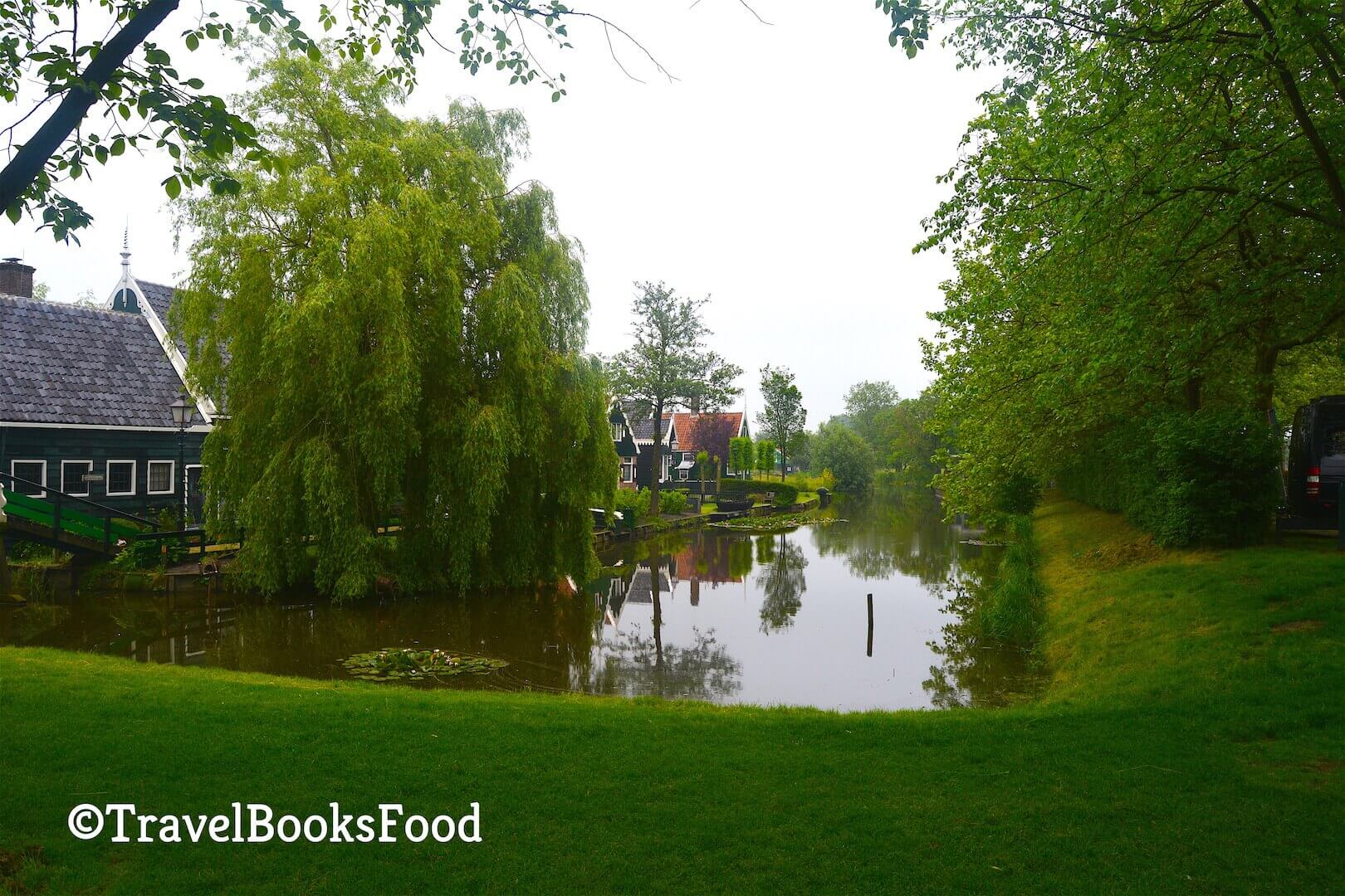 Another photo of the Zaanse Schaans Fishing village with lots of green houses, a pond surrounded by greenery
