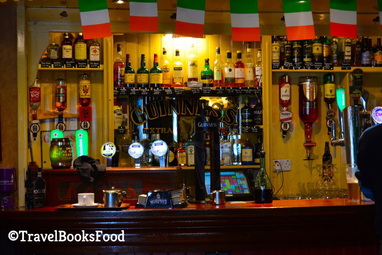 A Photo of a bar in Ireland with lots of bottles and Guinness Taps