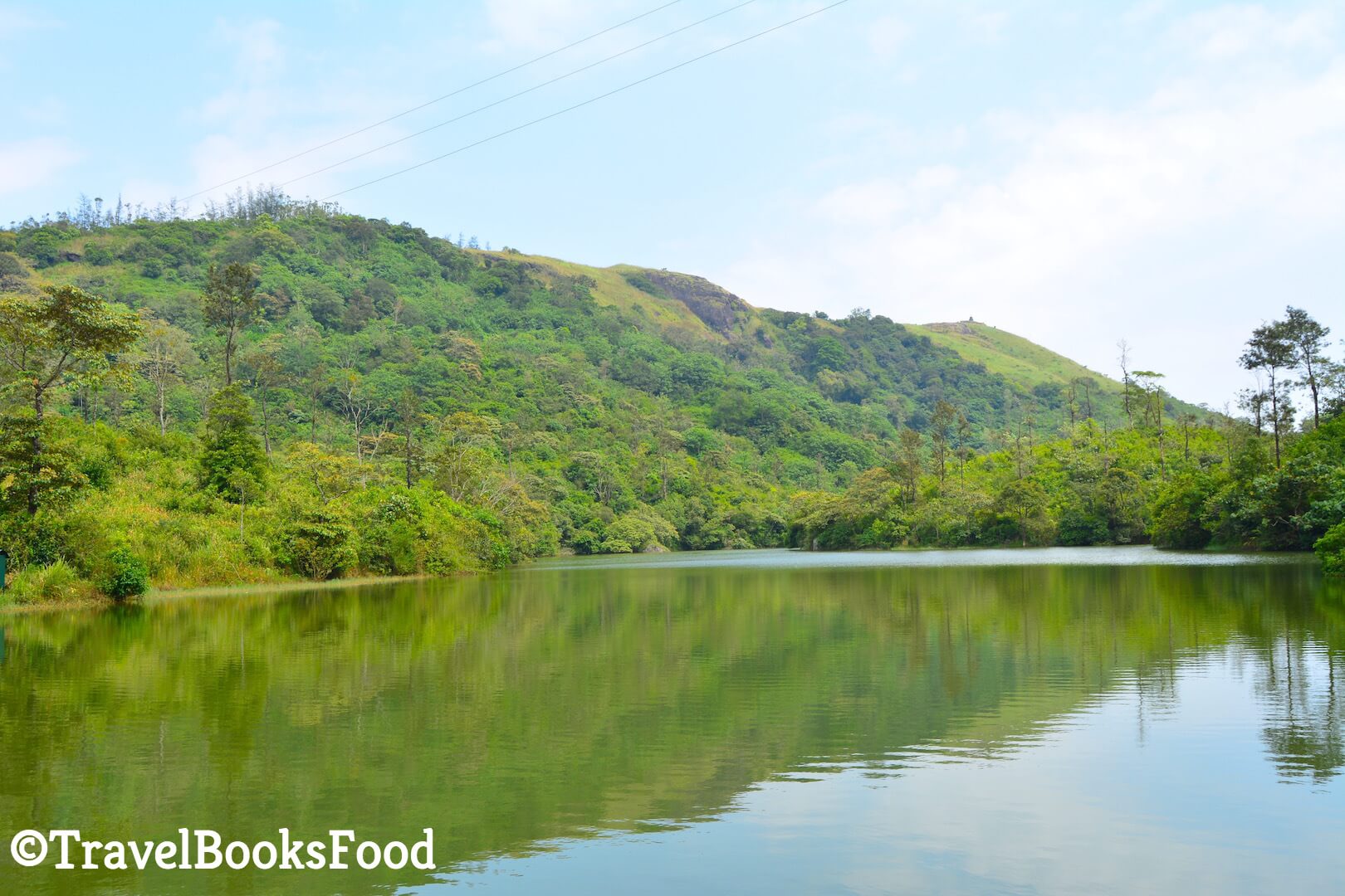 A green colored lake surrounded by mountains in Kerala, India