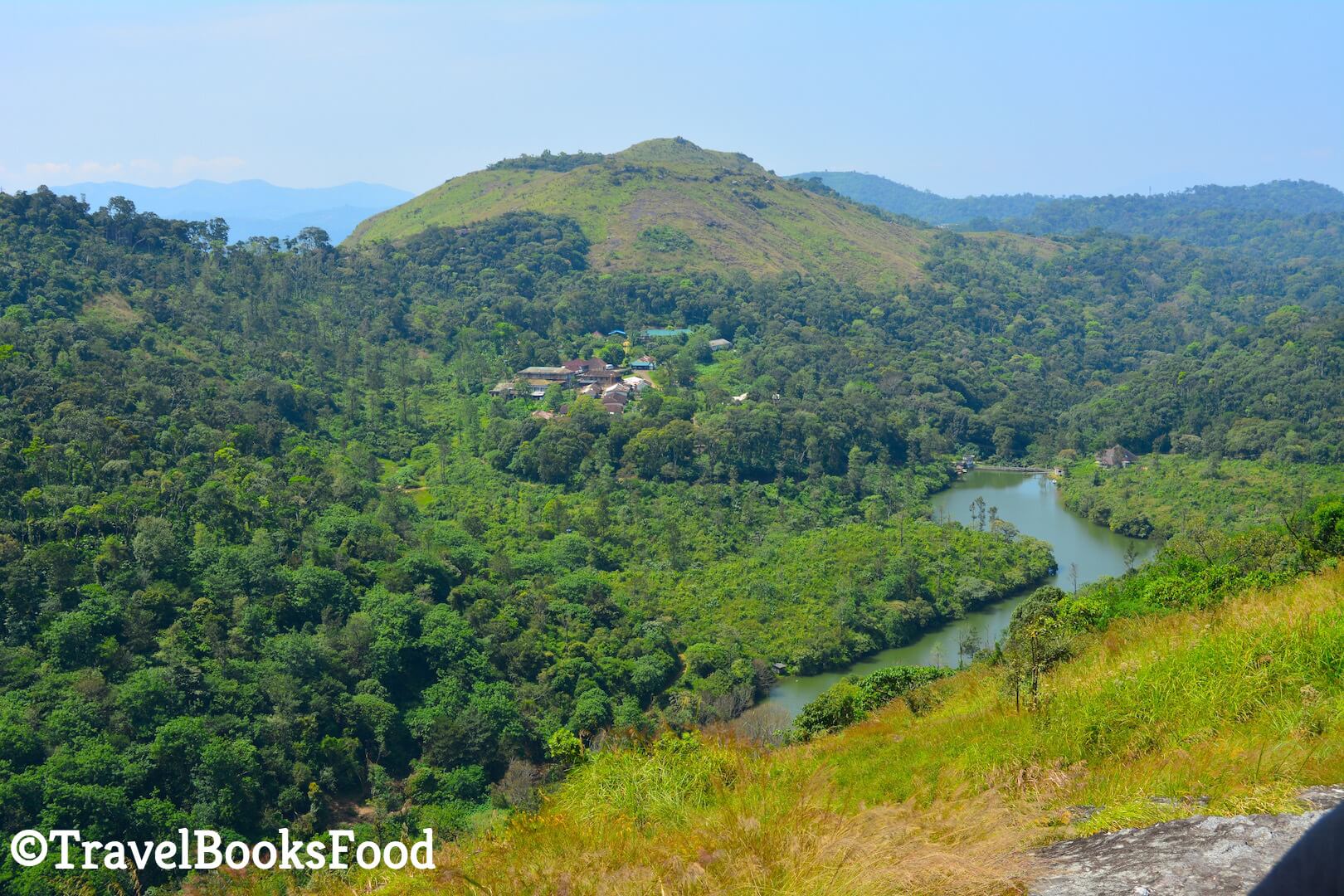View of a waterbody and lots of mountains in the distance from a height in Kerala, India
