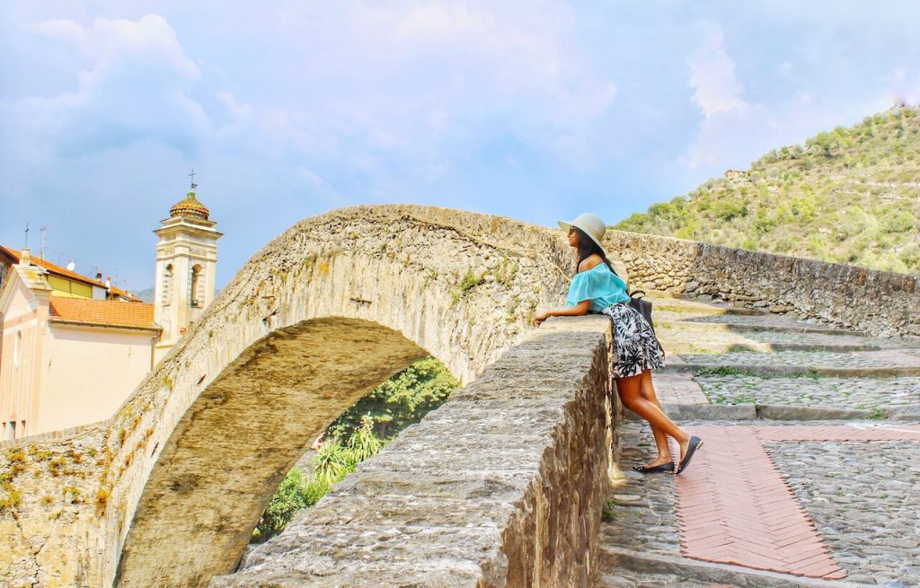 A photo of a lady looking into the expanse from a limestone bridge