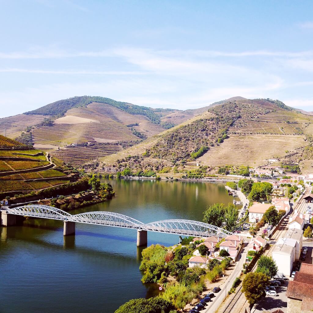 A photo of a bridge and mountains taken from a distance in Duoro Valley