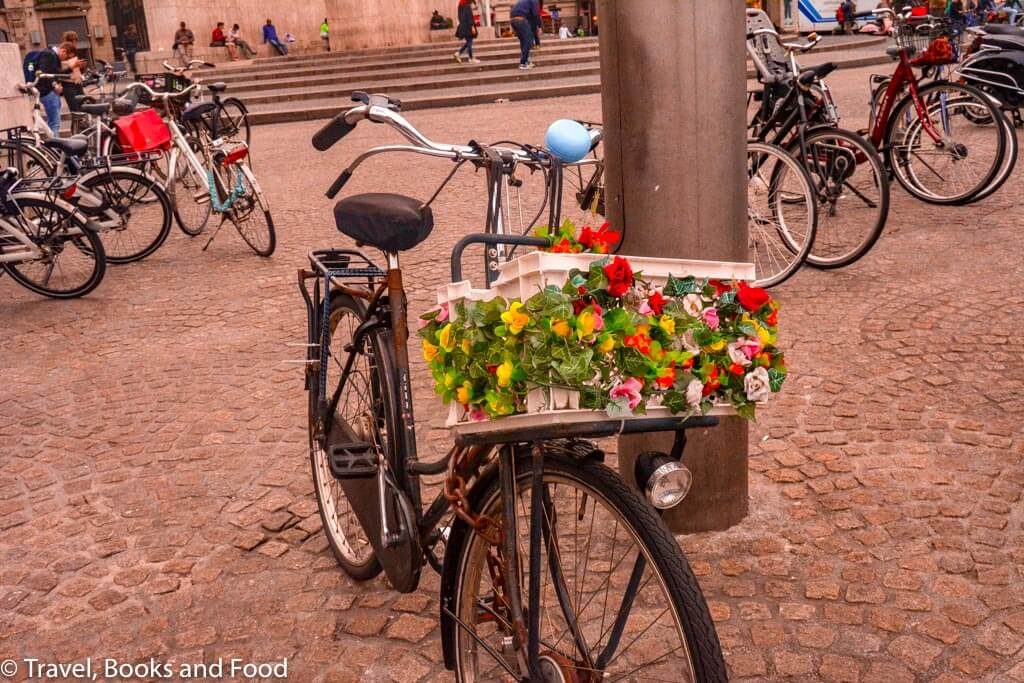 A cycle in a street with a colourful flower basket in Amsterdam, a must for your European vacation