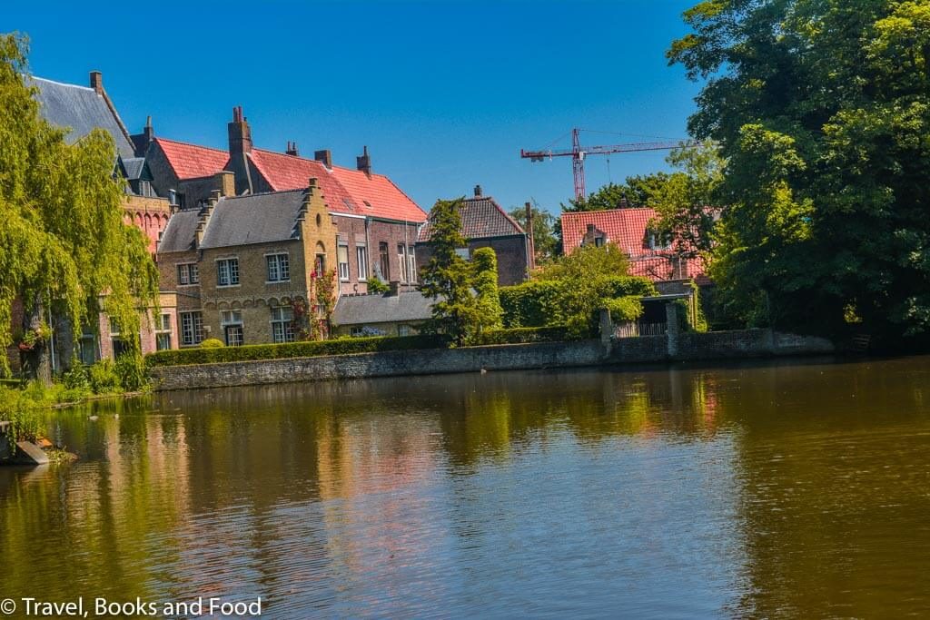 The pretty UNESCO heritage site of Bruges with canals, trees and buildings with orange tiles