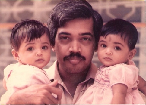 Dad carrying his twins on each arm
